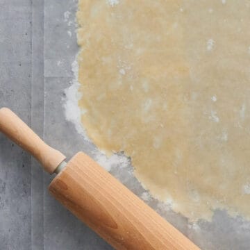 close up of pie crust being rolled out with rolling pin